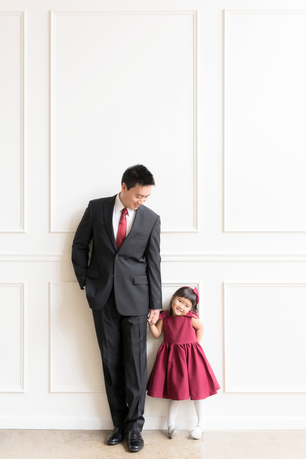 A daughter holds her dad’s hand and laughs during a downtown Chicago family photoshoot.