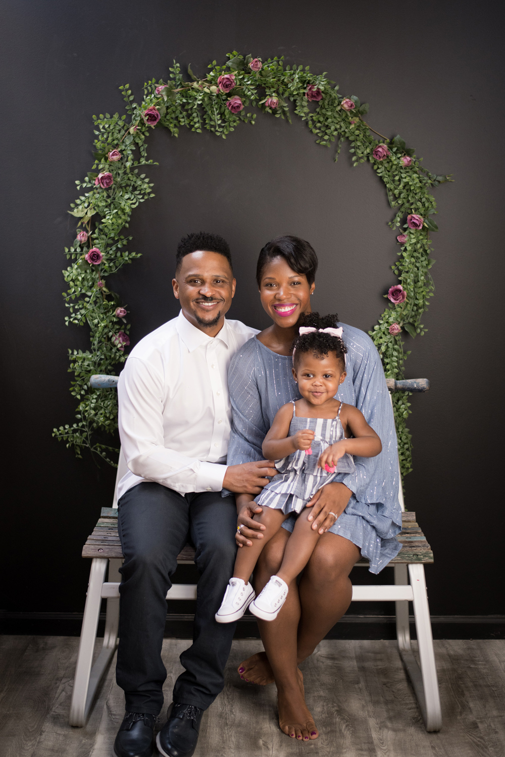 A Chicago family smiles in front of a wreath during a photo session.