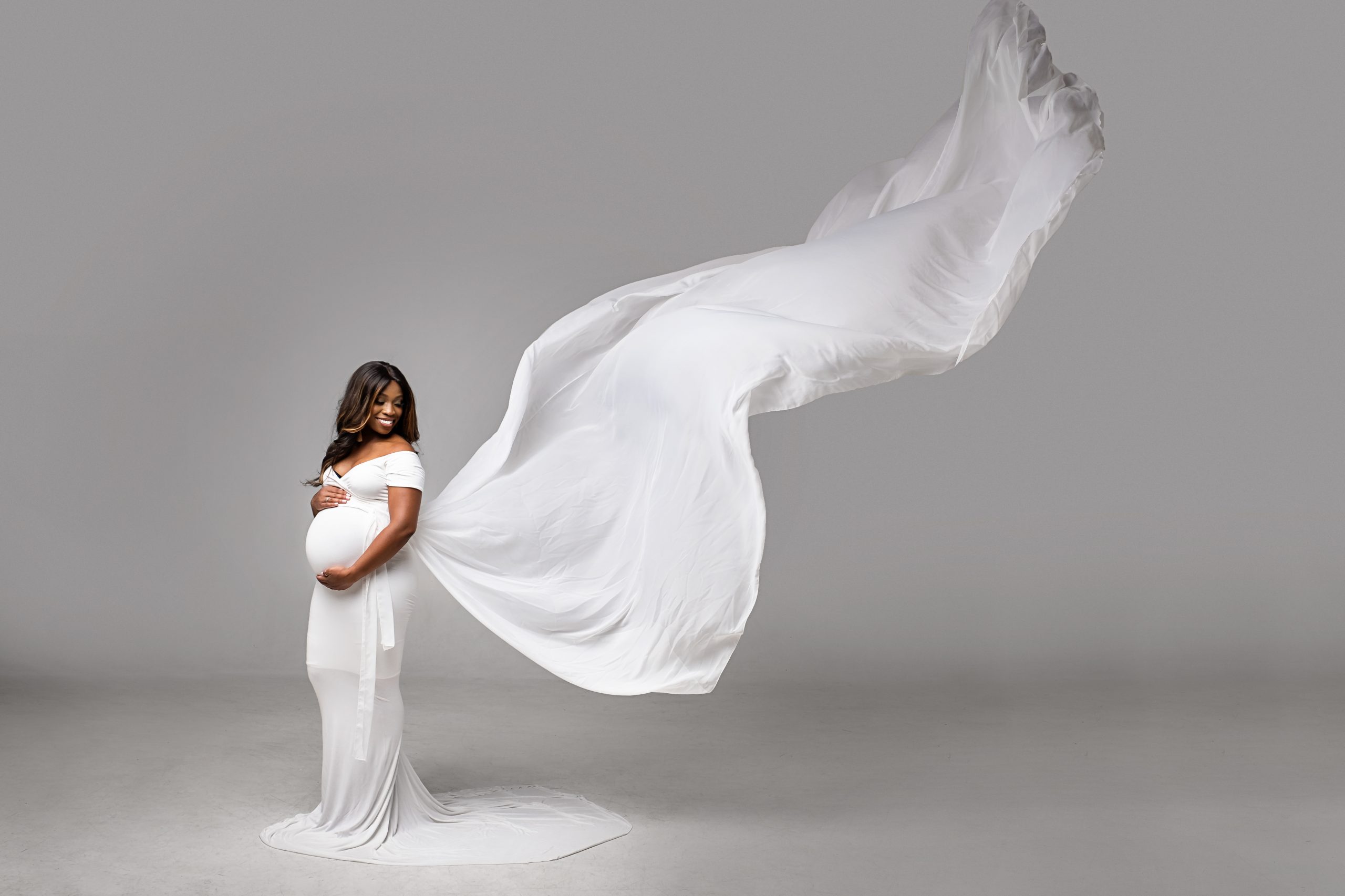 Synticee Denmark wearing white maternity long dress in heart shaped cleavage